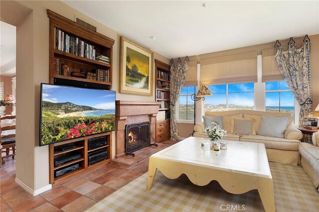 tiled living area featuring a lit fireplace and built in features