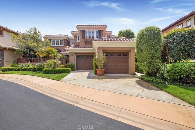 mediterranean / spanish-style house with concrete driveway, a tiled roof, and stucco siding