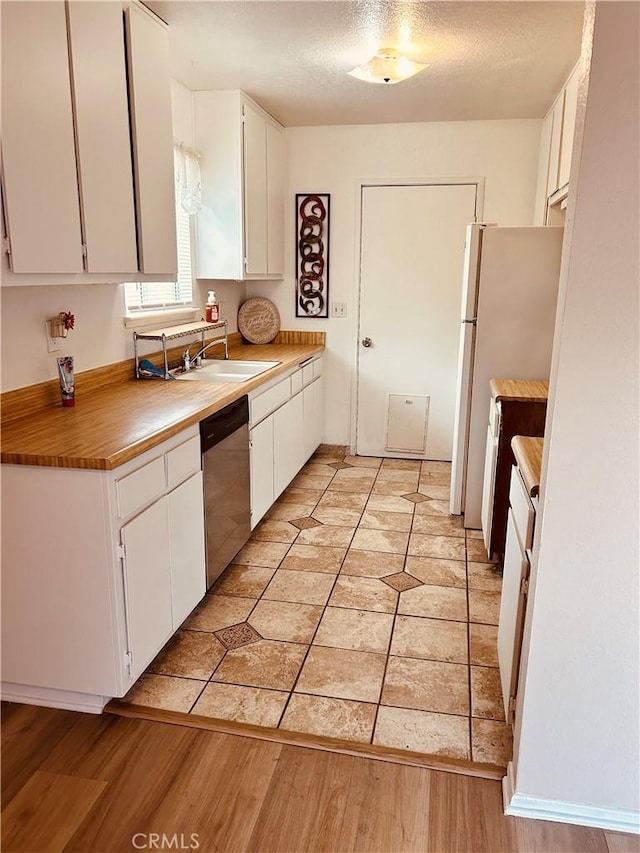 6252 Maloof Ave, Fontana, CA 92336 - kitchen with white cabinetry, freestanding refrigerator, a textured ceiling, light wood finished floors, and dishwasher