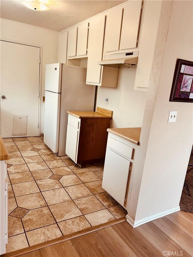 6252 Maloof Ave, Fontana, CA 92336 - kitchen with white cabinets, under cabinet range hood, light wood-style floors, and light countertops