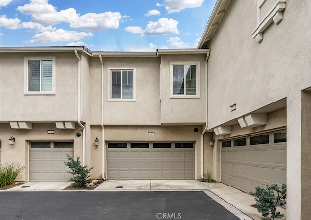view of front of home featuring driveway, stucco siding, and a garage