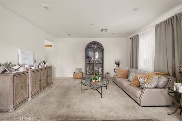 living area featuring light colored carpet and visible vents