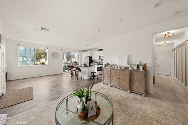 living area with baseboards and visible vents