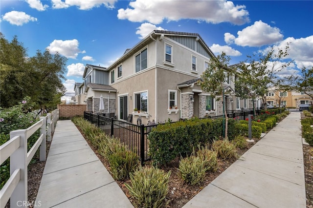 view of property exterior with a fenced front yard and stucco siding