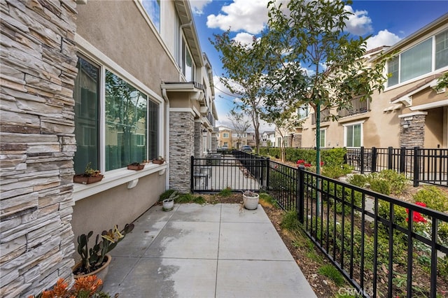 view of patio / terrace featuring fence and a residential view