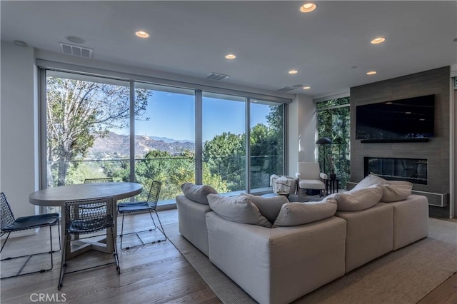 living room featuring visible vents, recessed lighting, wood finished floors, and a fireplace