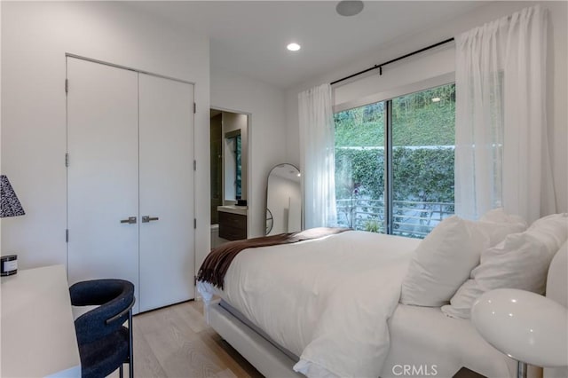 bedroom with a closet, recessed lighting, and light wood-type flooring