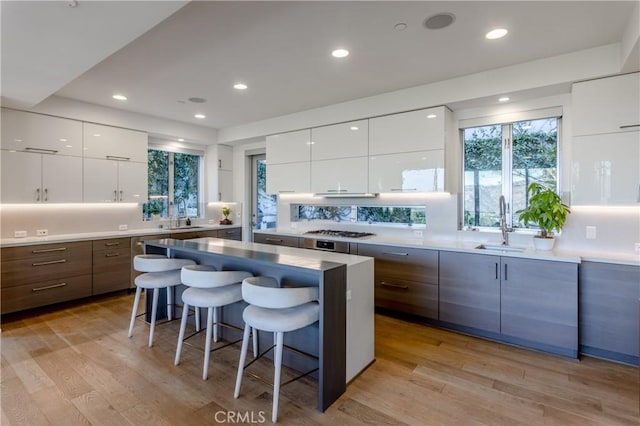 kitchen with light wood-type flooring, a kitchen bar, and modern cabinets