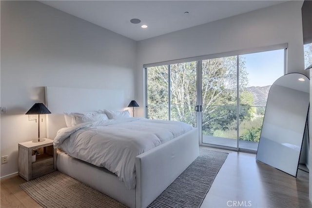 bedroom featuring recessed lighting, light wood-type flooring, multiple windows, and access to exterior