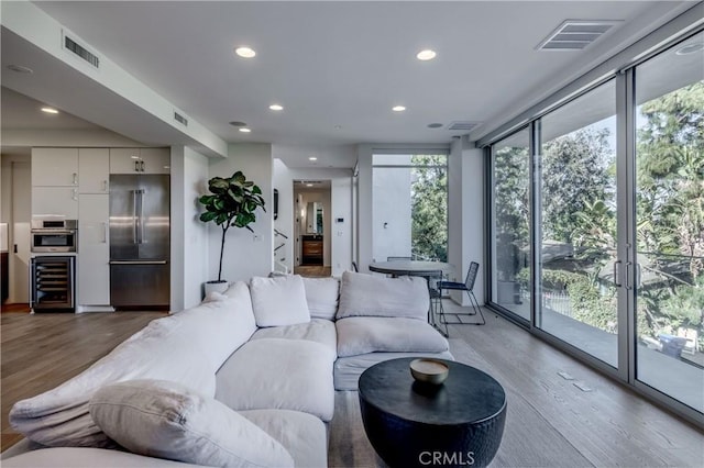 living area with visible vents and wood finished floors