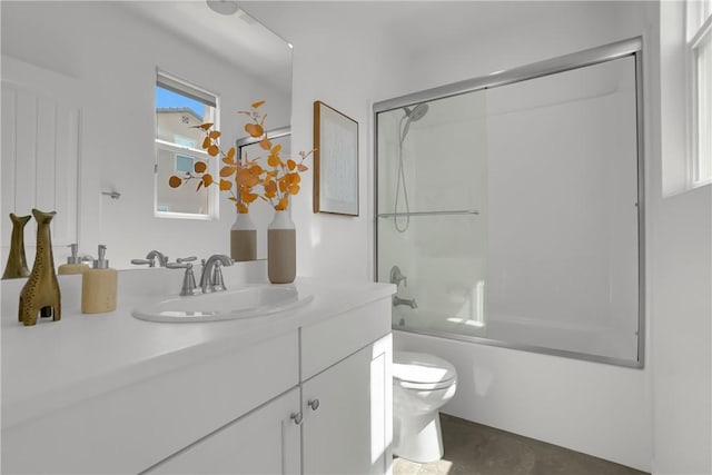 full bath with toilet, vanity, and bath / shower combo with glass door