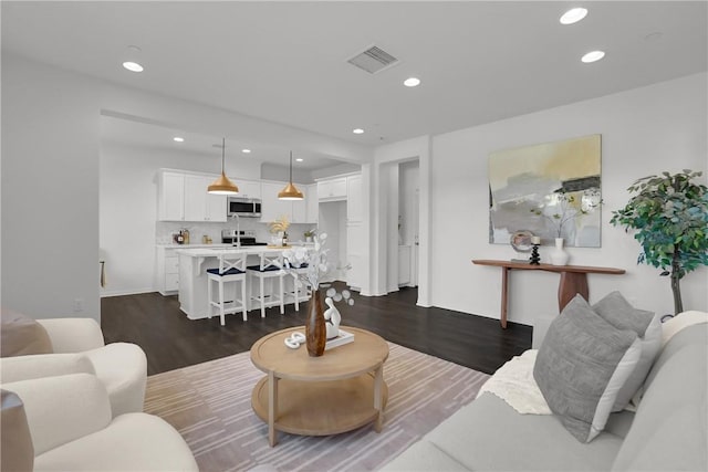 living room featuring recessed lighting, visible vents, and dark wood-style flooring
