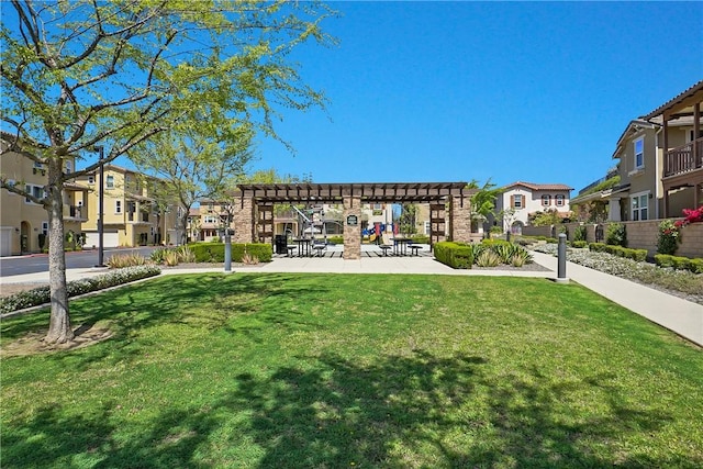 view of community with a pergola, a lawn, and a residential view
