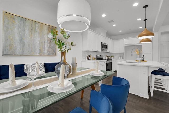 kitchen featuring a sink, stainless steel appliances, light countertops, dark wood-style floors, and recessed lighting
