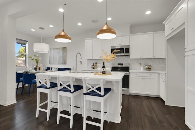 kitchen featuring dark wood-style floors, a sink, stainless steel microwave, light countertops, and electric stove