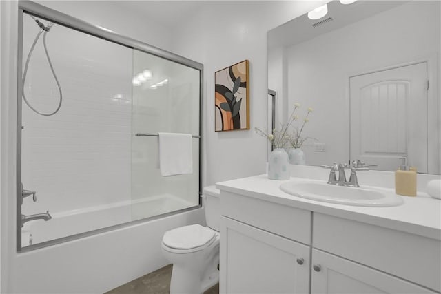 bathroom featuring combined bath / shower with glass door, visible vents, vanity, and toilet
