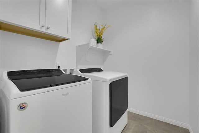 laundry area with baseboards, washer and clothes dryer, and cabinet space