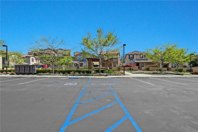 uncovered parking lot featuring a residential view and mail area
