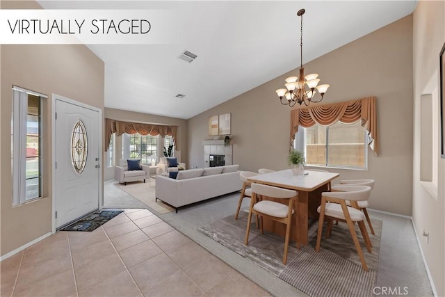 74119 Academy Ln E, Palm Desert, CA 92211 - dining space featuring vaulted ceiling, a chandelier, baseboards, light tile patterned floors, and a fireplace