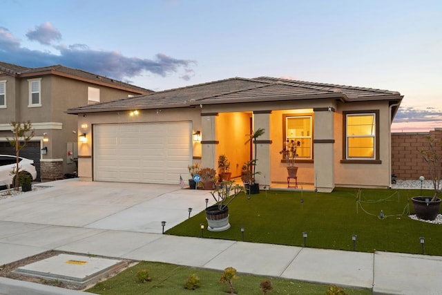 view of front of property with a garage, stucco siding, concrete driveway, and a tiled roof