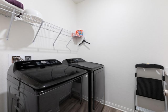 laundry area with baseboards, separate washer and dryer, laundry area, and wood finished floors