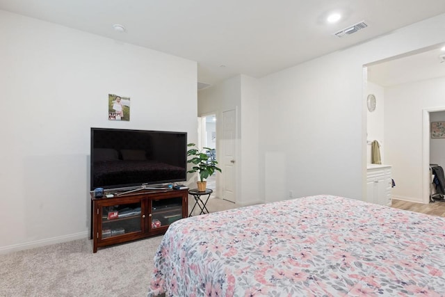 bedroom featuring baseboards, visible vents, and light carpet