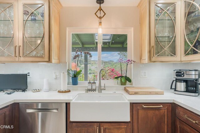 bar featuring stainless steel dishwasher, a sink, hanging light fixtures, and tasteful backsplash