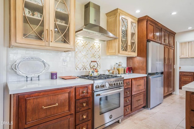 kitchen featuring recessed lighting, stainless steel appliances, light countertops, backsplash, and wall chimney exhaust hood