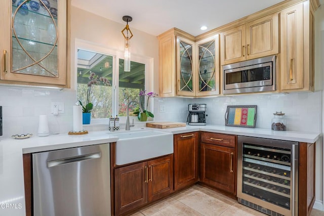 bar with wine cooler, a sink, backsplash, and appliances with stainless steel finishes