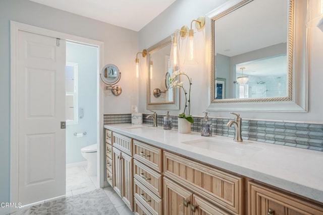 full bathroom with double vanity, toilet, and a sink