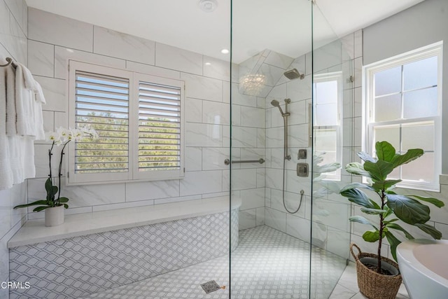 full bath with tile walls, a freestanding tub, and tiled shower