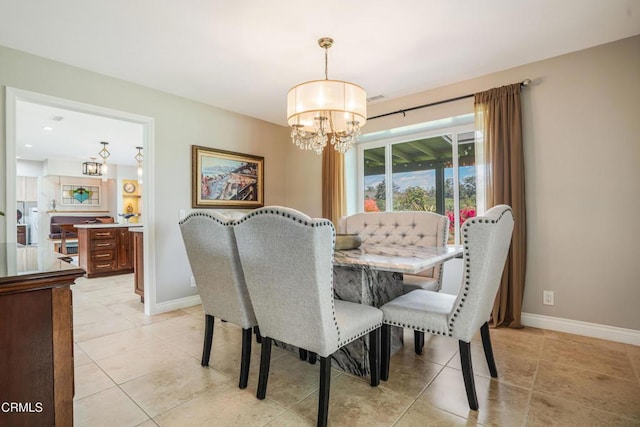 dining area with baseboards, a chandelier, and light tile patterned floors