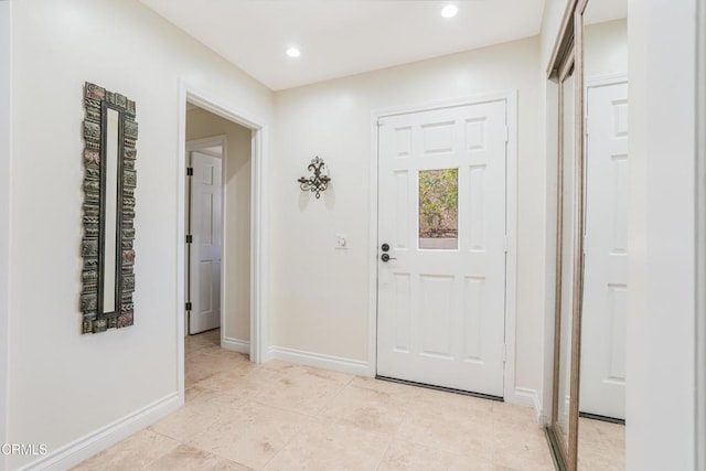 foyer entrance featuring baseboards, light tile patterned flooring, and recessed lighting