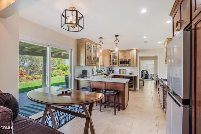 kitchen with beverage cooler, light countertops, a peninsula, glass insert cabinets, and appliances with stainless steel finishes