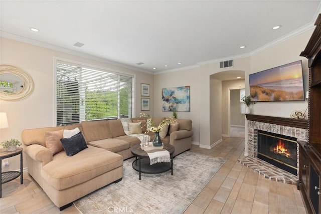 living room featuring arched walkways, light wood-style floors, visible vents, and a fireplace