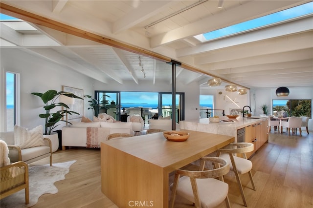 2604 Victoria Dr, Laguna Beach, CA 92651 - kitchen with a sink, beam ceiling, a skylight, light wood finished floors, and an island with sink
