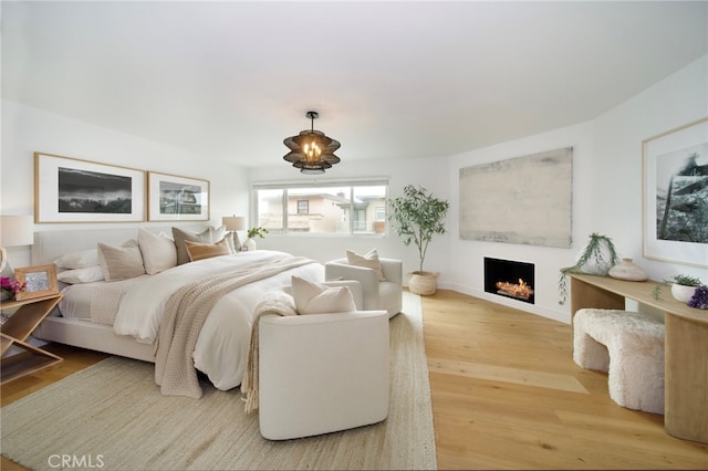2604 Victoria Dr, Laguna Beach, CA 92651 - bedroom with a warm lit fireplace, wood finished floors, and baseboards
