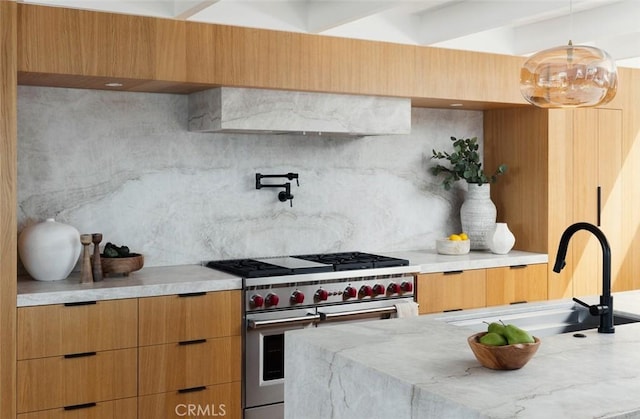 2604 Victoria Dr, Laguna Beach, CA 92651 - kitchen featuring double oven range, a sink, modern cabinets, decorative light fixtures, and light stone countertops