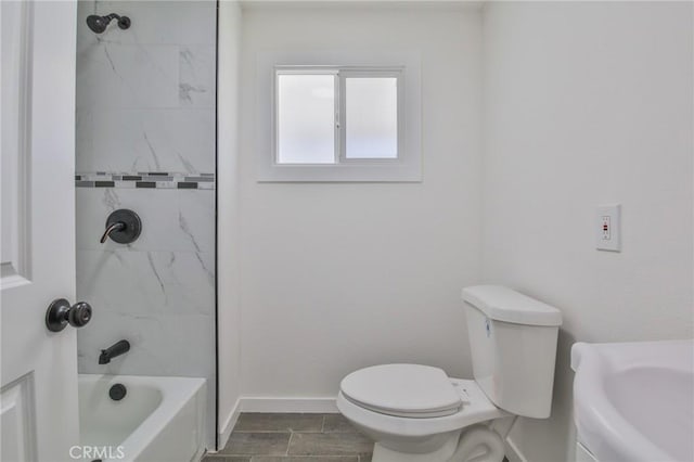 full bath featuring baseboards, toilet, and a sink