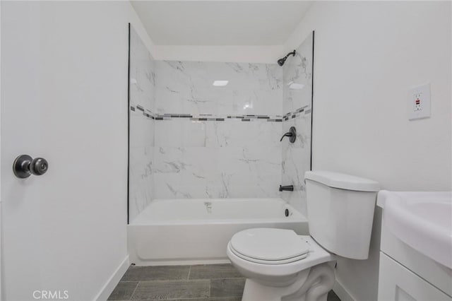bathroom featuring toilet, vanity, baseboards, and bathing tub / shower combination
