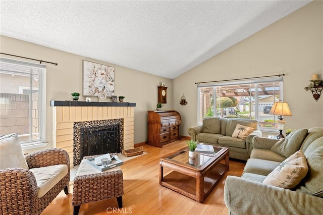 20140 Bouma Ct, Cerritos, CA 90703 - living room featuring a textured ceiling, wood finished floors, healthy amount of natural light, vaulted ceiling, and a brick fireplace