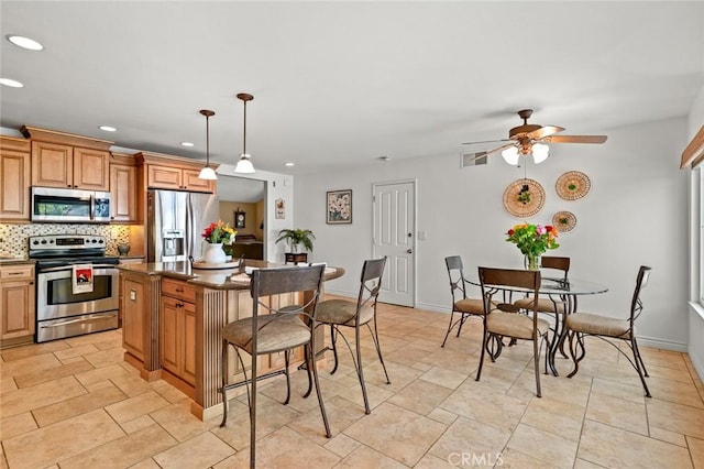 20140 Bouma Ct, Cerritos, CA 90703 - kitchen with appliances with stainless steel finishes, a kitchen bar, recessed lighting, dark countertops, and decorative backsplash