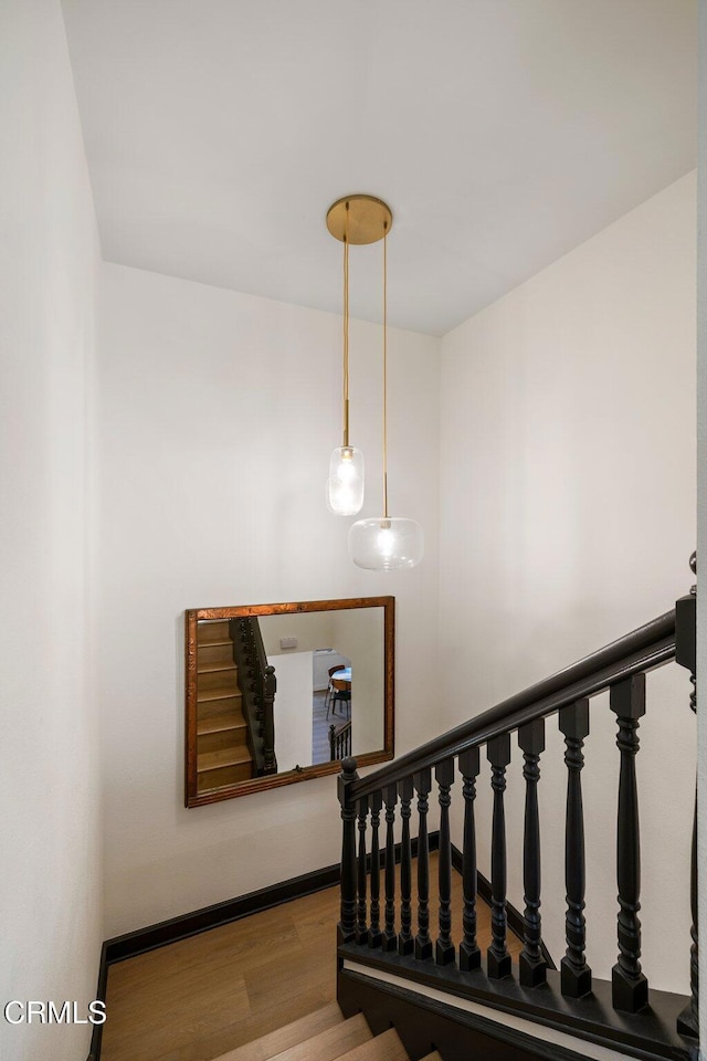 staircase with wood finished floors and baseboards