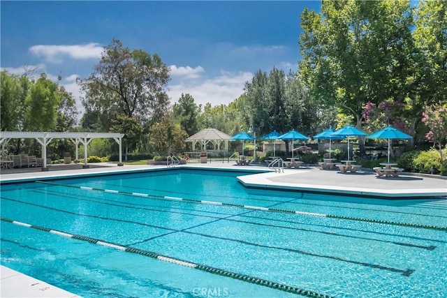 24118 Saint Moritz Dr, Valencia, CA 91355 - community pool featuring a pergola, a patio area, and view of wooded area