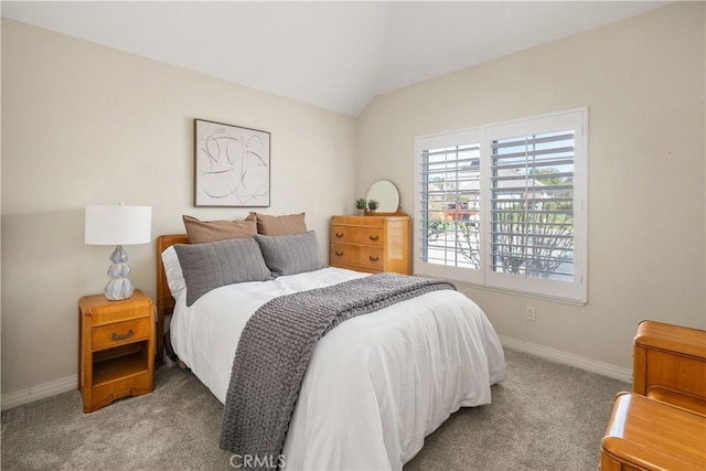 bedroom with vaulted ceiling, carpet floors, and baseboards
