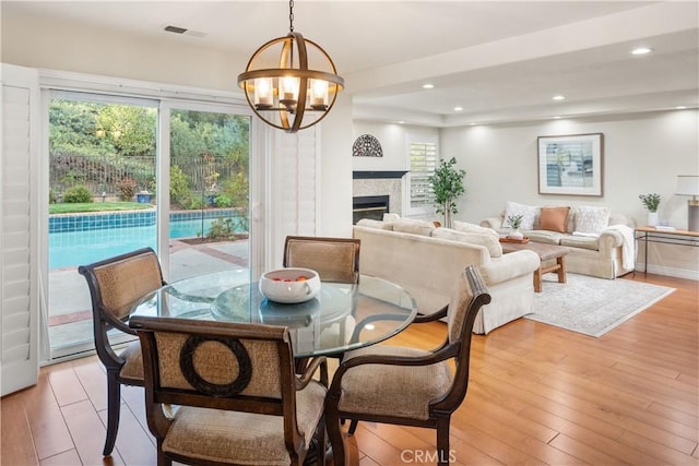 dining room featuring a chandelier, visible vents, a wealth of natural light, and light wood finished floors