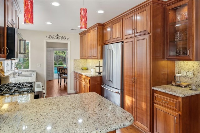 24118 Saint Moritz Dr, Valencia, CA 91355 - kitchen featuring appliances with stainless steel finishes, decorative backsplash, light wood finished floors, light stone countertops, and recessed lighting