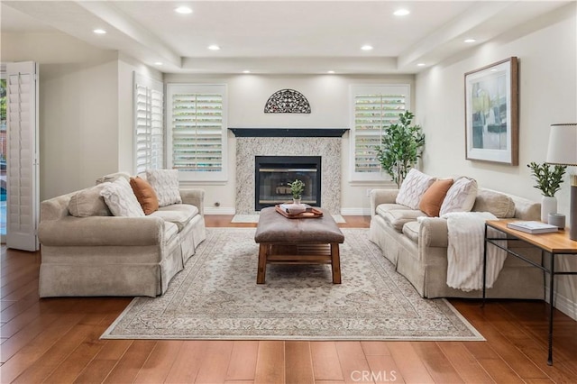 living room featuring recessed lighting, hardwood / wood-style flooring, and a premium fireplace