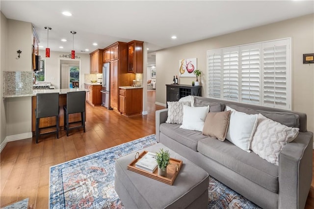 living room featuring recessed lighting, light wood finished floors, and baseboards