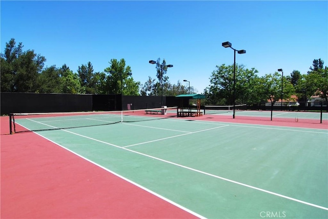 view of tennis court with fence and community basketball court